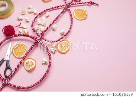 Flatly Survakane, Survachka On Pink Background. Bulgarian Traditional Cornel Stick With Decorations, Dried Fruits, Threads, Popcorn. Christmas Entertainment. Copy space For text, Horizontal Plane Flatly Survakane, Survachka On Pink Background. Bulgarian Traditional Cornel Stick With Decorations, Dried Fruits, Threads, Popcorn. Christmas Entertainment. Copy space For text, Horizontal Plane 101026159