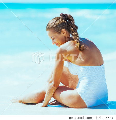 Young woman sitting at seaside. rear view 101026385