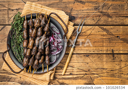 Churrasco Brazilian barbecue, chicken hearts grilled kebabs with herbs and vegetables. Wooden background. Top view. Copy space Churrasco Brazilian barbecue, chicken hearts grilled kebabs with herbs and vegetables. Wooden background. Top view. Copy space 101026534