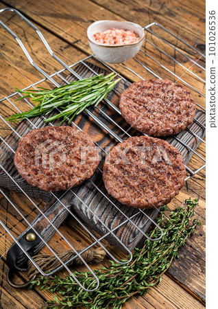 BBQ Grilled burger beef meat steak on grill with herbs. Wooden background. Top view BBQ Grilled burger beef meat steak on grill with herbs. Wooden background. Top view 101026536