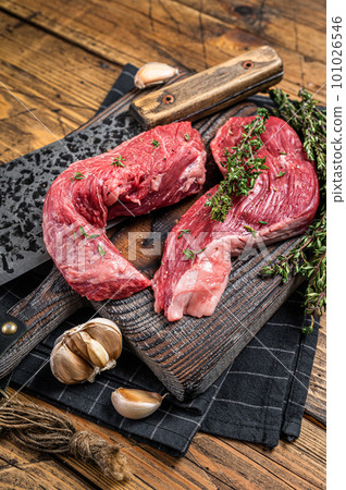 Raw Sirloin flap or Bavette raw beef meat steak on a wooden butcher board with meat cleaver. Wooden background. Top view 101026546