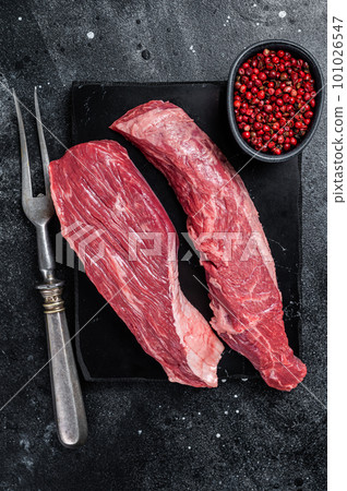 Bavette raw beef meat steak or Sirloin flap on marble board. Black background. Top view 101026547