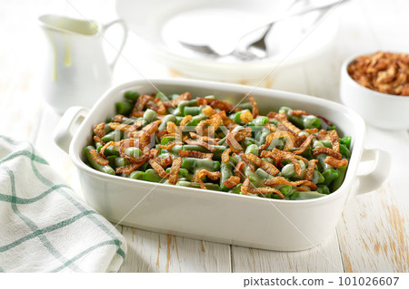 Roasted green bean with crispy fried onions served in a ceramic form on a wooden table. Healthy root vegetables concept. 101026607