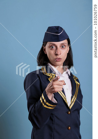 Young serious flight attendant pointing at camera with finger, aviation academy recruitment concept. Confident airlines stewardess in professional uniform portrait front view Young serious flight attendant pointing at camera with finger, aviation academy recruitment concept. Confident airlines stewardess in professional uniform portrait front view 101026759