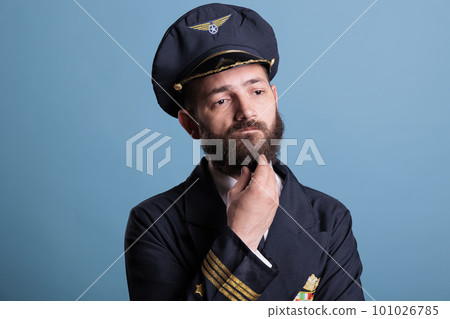 Thoughtful unsure airline pilot in uniform thinking, touching chin, making decision, idea generation. Pensive plane aviator with doubtful uncertain facial expression portrait Thoughtful unsure airline pilot in uniform thinking, touching chin, making decision, idea generation. Pensive plane aviator with doubtful uncertain facial expression portrait 101026785