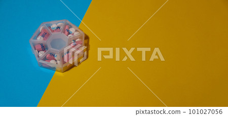 Organizer weekly shots medical pill box with doses of tablets for daily take medicine with white pink drugs and capsules. Copy space Daily vitamins at home. Health care and diseases cure 101027056