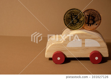 Bitcoin gold coin with wooden toy car. Saving and manage money for transport car loan mining trading concept. Automotive transportation industry merge with technology exchange financial market can pay Bitcoin gold coin with wooden toy car. Saving and manage money for transport car loan mining trading concept. Automotive transportation industry merge with technology exchange financial market can pay 101027126