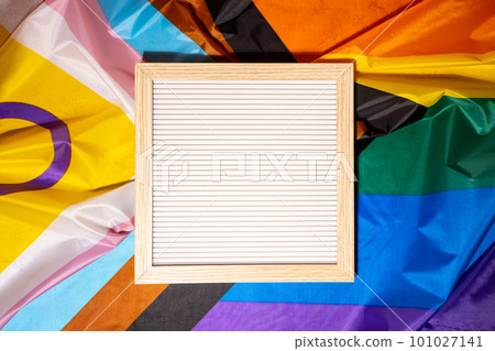 Empty blank frame on Rainbow LGBTQIA flag made from silk material with copy space for your text. Mock up template. Symbol of LGBTQ pride month. Equal rights. Peace and freedom. Support LGBTQIA Empty blank frame on Rainbow LGBTQIA flag made from silk material with copy space for your text. Mock up template. Symbol of LGBTQ pride month. Equal rights. Peace and freedom. Support LGBTQIA 101027141