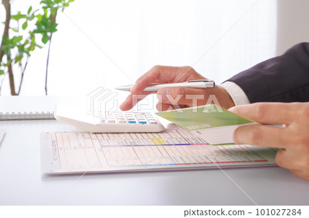 一個穿西裝的男人在做計算 一個穿西裝的男人在做計算 101027284
