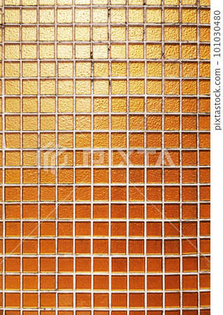Building wall decorated with small square golden tiles. Orange glass tiling in a swimming pool. Textured background Building wall decorated with small square golden tiles. Orange glass tiling in a swimming pool. Textured background 101030480