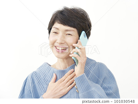 一位中年婦女撫摸著胸部，用智能手機打電話 白色背景 101030548