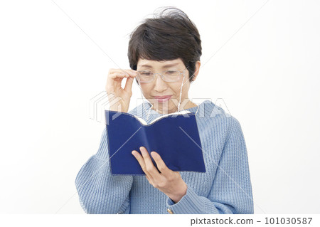 Middle-aged woman reading with reading glasses on a white background 101030587