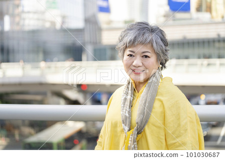 一個 60 多歲的女人對著鏡頭微笑的肖像 101030687