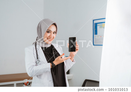 a beautiful doctor pointing on the phone at her hand a beautiful doctor pointing on the phone at her hand 101031013