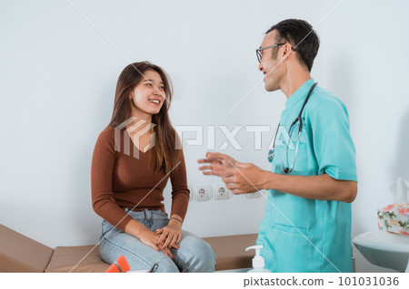 a patient sitting on the bed and smiling to the male nurse 101031036