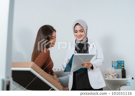 a female doctor come near to the female patient 101031116