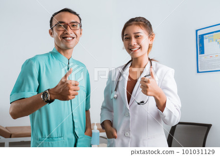 a beautiful doctor and a handsome nurse standing with thumbs up a beautiful doctor and a handsome nurse standing with thumbs up 101031129