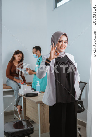 a beautiful doctor standing with oke gesture and smilling 101031149