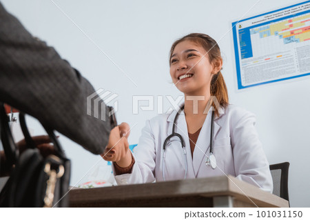 a female doctor with long brown hair hand shake with the patient 101031150