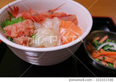 Luxurious seafood rice bowl and small bowl of vegetables on a black tray 101031586