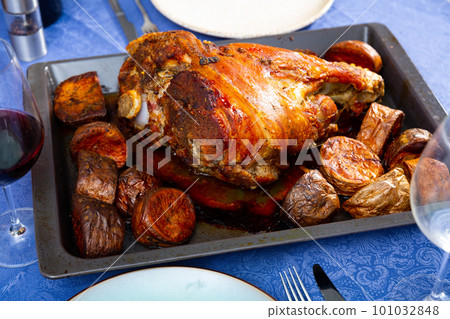 Oven baked pork leg with side dish of potatoes in baking tray Oven baked pork leg with side dish of potatoes in baking tray 101032848