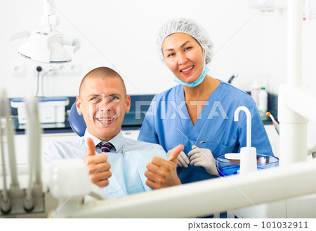 Portrait of satisfied man visiting dentist giving thumbs up in the dental clinic Portrait of satisfied man visiting dentist giving thumbs up in the dental clinic 101032911