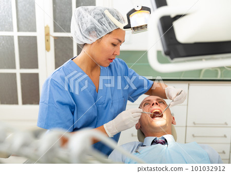 Woman doctor treats patient teeth using boron machine in clinic Woman doctor treats patient teeth using boron machine in clinic 101032912