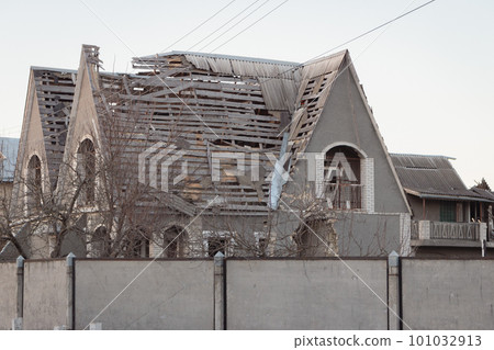 Destroyed building after russian invasion, Ukraine. Ruined facade of house. War in Ukraine. Broken windows and roof after attack. Abandoned damaged home. War disaster. Hole in walls after attack. 101032913