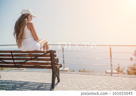 Woman summer travel sea. Happy tourist enjoy taking picture outdoors for memories. Woman traveler posing over sea bay surrounded by volcanic mountains, sharing travel adventure journey Woman summer travel sea. Happy tourist enjoy taking picture outdoors for memories. Woman traveler posing over sea bay surrounded by volcanic mountains, sharing travel adventure journey 101033045