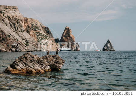 Remote beach, calm sea with volcanic rocky shores, with small waves on the water surface. The summer ocean beach, a holiday, vacation, and travel concept with a focus on natural scenery. Nobody Remote beach, calm sea with volcanic rocky shores, with small waves on the water surface. The summer ocean beach, a holiday, vacation, and travel concept with a focus on natural scenery. Nobody 101033091