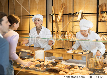 Smiling aged female baker working behind counter in bakery shop 101033426