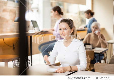 Portrait of attractive girl drinking coffee in modern cafe Portrait of attractive girl drinking coffee in modern cafe 101034350