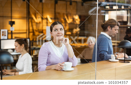 Calm woman enjoying peace and quiet alone in cozy cafe 101034357
