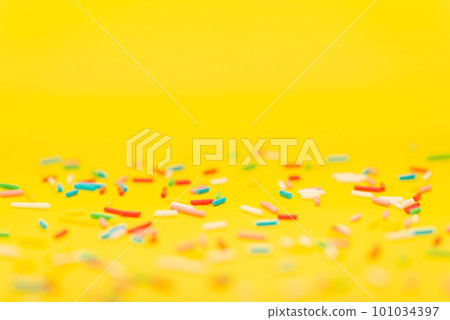 colorful sprinkles over yellow background 101034397