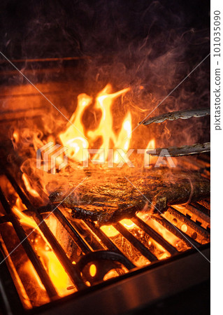 Beef steak on the grill with flames 101035090