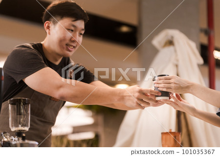 Asian man, coffee maker, handing over a cup of coffee Served to female customers counter, Startup Business Concept. Asian man, coffee maker, handing over a cup of coffee Served to female customers counter, Startup Business Concept. 101035367