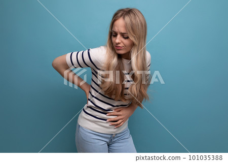 sad girl holding her stomach because of being unwell on a blue isolated background sad girl holding her stomach because of being unwell on a blue isolated background 101035388