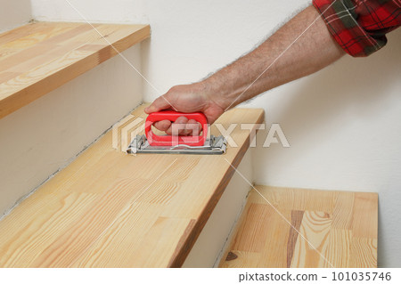 Home renovation, worker sanding wooden stairs Home renovation, worker sanding wooden stairs 101035746