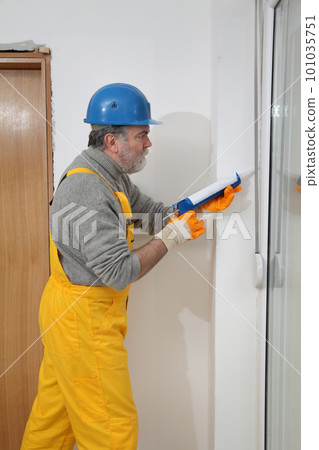 Worker installing PVC door, using silicone cartidge 101035751