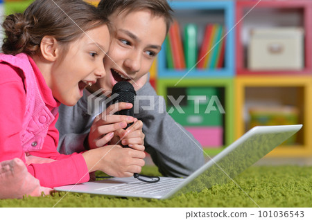 Adorable little girl and boy singing karaoke 101036543