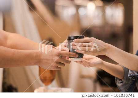 Asian man, coffee maker, handing over a cup of coffee Served to female customers counter, Startup Business Concept. Asian man, coffee maker, handing over a cup of coffee Served to female customers counter, Startup Business Concept. 101036741