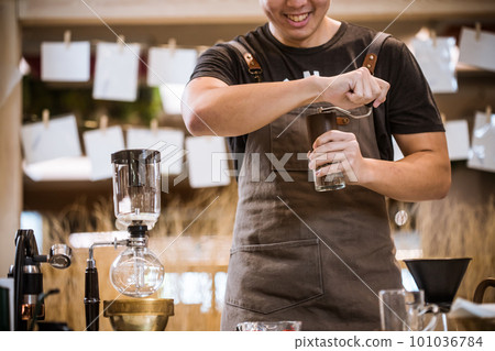 Professional coffee maker - Barista using coffee siphon brewing hot espresso at coffee shop coffee brewing syphon alternative method. Startup Business Concept. 101036784