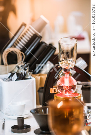 Professional coffee maker - Barista using coffee siphon brewing hot espresso at coffee shop coffee brewing syphon alternative method. Startup Business Concept. Professional coffee maker - Barista using coffee siphon brewing hot espresso at coffee shop coffee brewing syphon alternative method. Startup Business Concept. 101036788