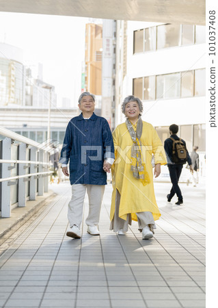 Smiling couple in their 60s walking in the city Smiling couple in their 60s walking in the city 101037408