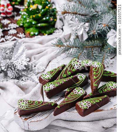 Chocolate brownies in shape of christmas trees with green icing 101037521
