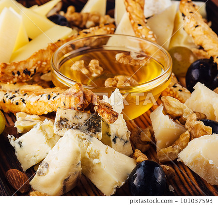 Cheese plate with honey, grapes and nuts Cheese plate with honey, grapes and nuts 101037593