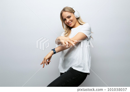 blond girl in headphones enjoys music on a white background 101038037