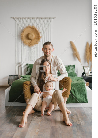 Portrait of a beautiful young family with a baby at home Portrait of a beautiful young family with a baby at home 101038104