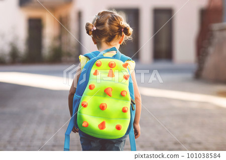 Cute little adorable toddler girl on her first day going to playschool. Healthy beautiful baby walking to nursery school and kindergarten. Happy child with backpack, unrecognizable face. 101038584