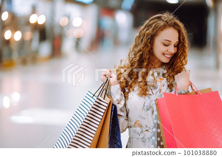 Fashionable woman with multi-colored bags in modern shop center. The joy of consumption. Fashionable woman with multi-colored bags in modern shop center. The joy of consumption. 101038880